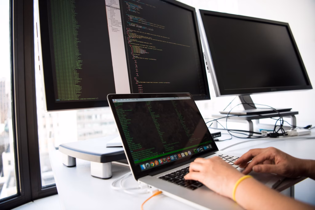 Il costo dell'inferenza: la vera barriera per l'IA — software developer analyzing system architecture diagrams on multiple screens