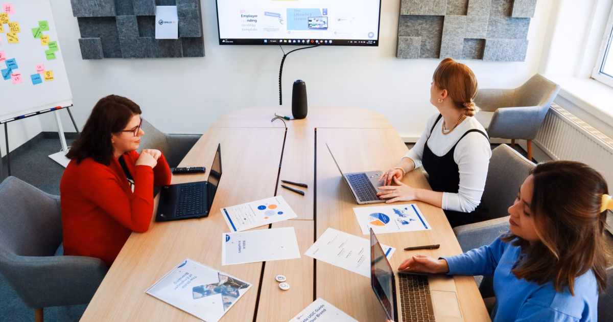 Formare i dipendenti all'IA generativa: guida all'upskilling — corporate training room with employees collaborating on laptops and digital screens, professional setting