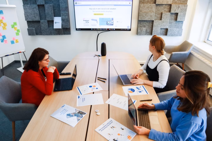 Formare i dipendenti all'IA generativa: guida all'upskilling — corporate training room with employees collaborating on laptops and digital screens, professional setting