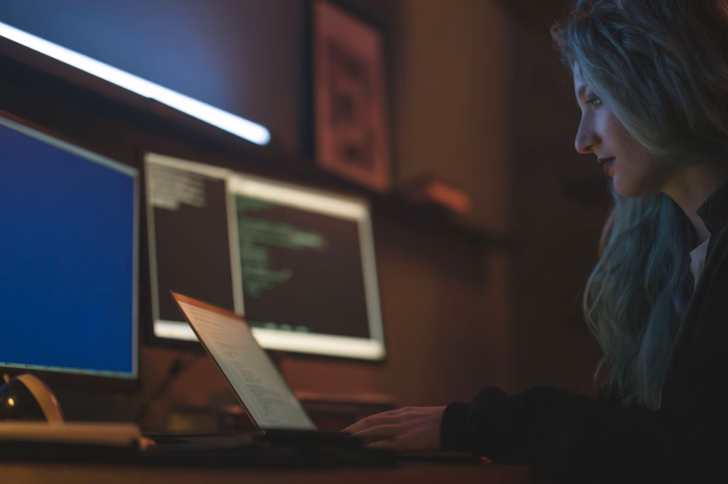 La trappola del debito tecnico generato dall'IA — stressed software developer looking at multiple computer monitors with code