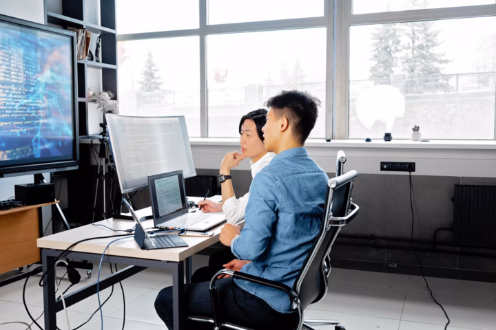 Come condurre un AI readiness assessment aziendale — software engineers analyzing data on screens in modern office